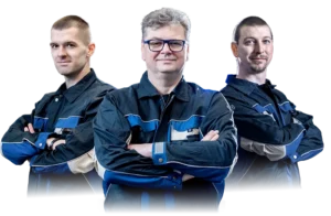 Three experienced technicians in work uniforms standing confidently with arms crossed, representing a professional industrial team.
