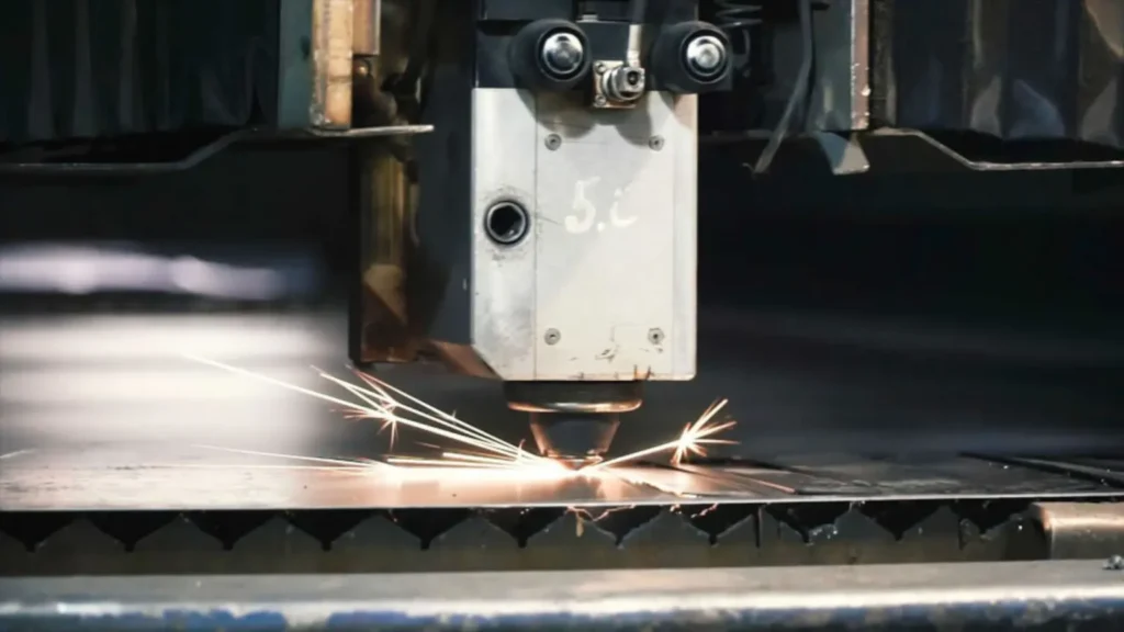 Close-up of a laser cutting head in operation during precision metal cutting.