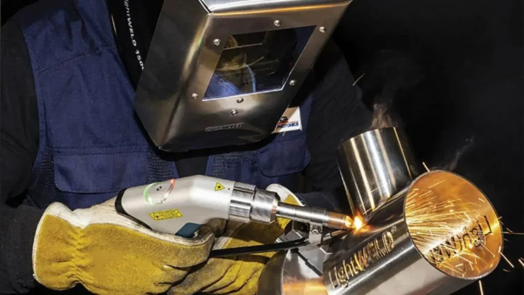 Welder operating a laser welding machine for precision metal joining.