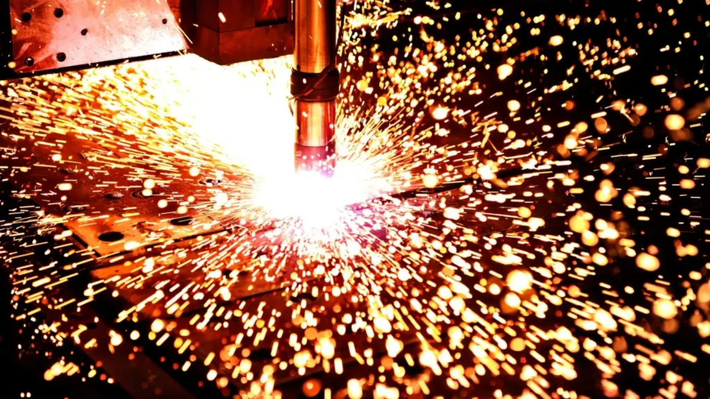 Plasma cutting of steel with visible sparks in an industrial environment.
