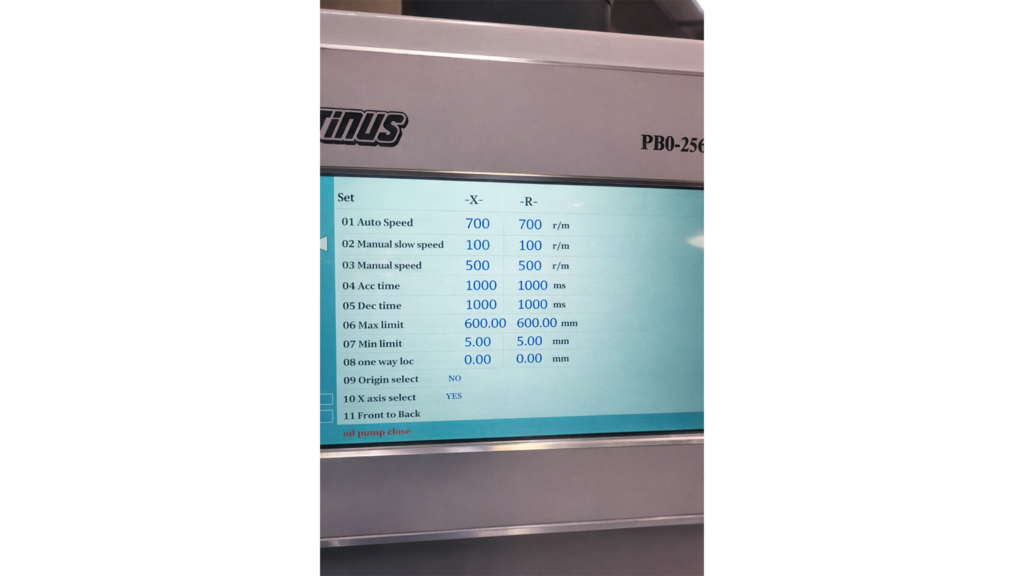 Delem DA-58T control panel on an Otinus press brake, displaying the input/output configuration screen, servo axis status, hydraulic system overview, and emergency stop button in a professional industrial environment.